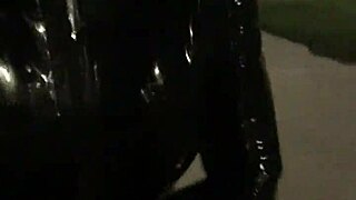 Crossdresser in latex struts outdoors with a vibrator buzzing in public.