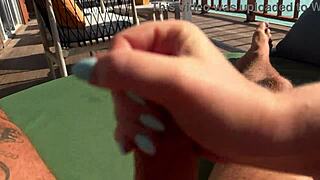 hot babe delivers a quick sloppy handjob on ocean terrace, risking it all