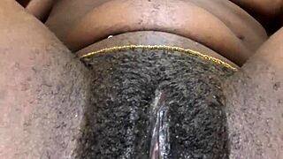 A beautiful black girl with a hairy pussy enjoys solo masturbation