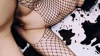 A lovely wife in a fishnet bodysuit spreadsOpens legs