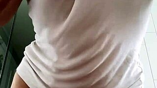 Baby oil drips on wet t-shirt as babe plays and teases.