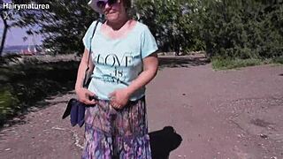 Hairy mature lady struts in a see-through dress outdoors.
